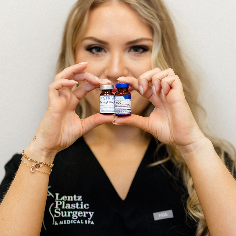 Physician-Directed Medical Weight Loss in Daytona Beach 1 Aesthetic specialist at Lentz Plastic Surgery & Medical Spa holding vials of Semaglutide and MICC medication.