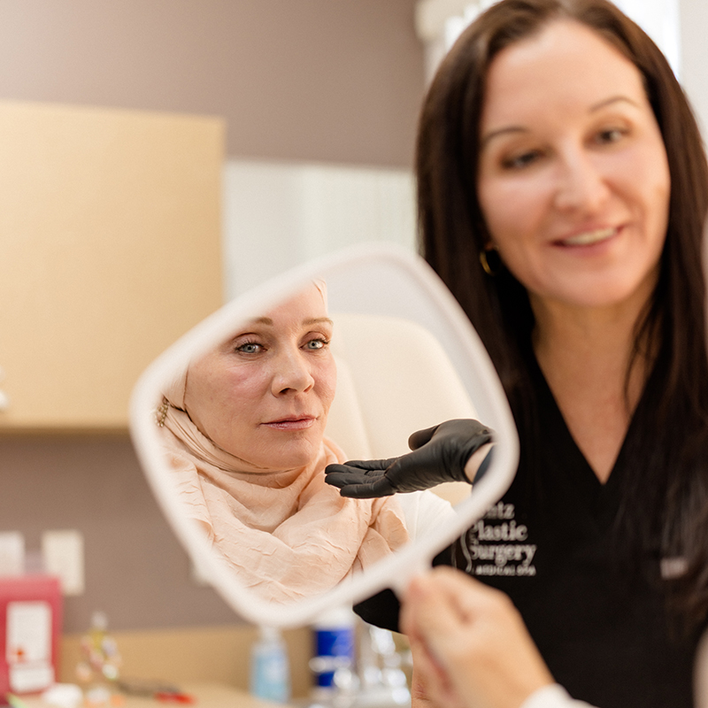 BOTOX Cosmetic 4 Professional aesthetician at Lentz Plastic Surgery & Medical Spa holding a mirror for a patient to review their clinical results.
