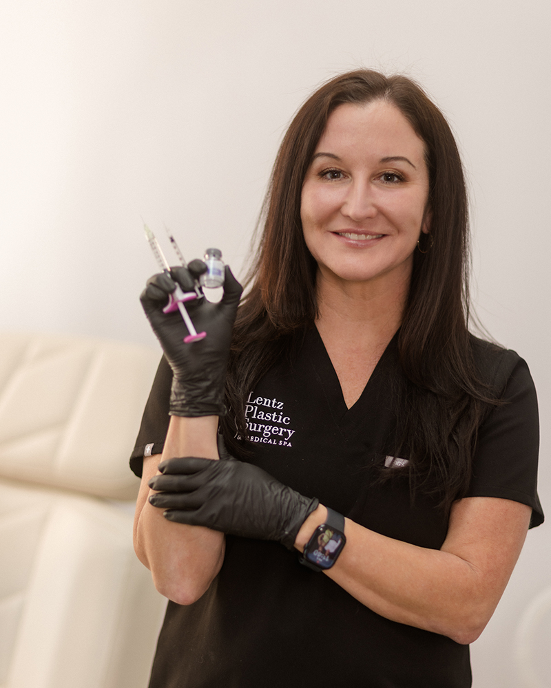 Restylane 2 Professional aesthetic provider at Lentz Plastic Surgery & Medical Spa wearing black scrubs and holding cosmetic injection syringes.